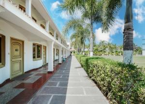 a walkway in front of a building with palm trees at Rupis Resort in Dabok