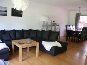 uma sala de estar com um sofá preto e uma mesa em Nyhyttan Modern retreat em Nora