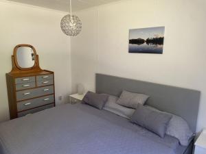 um quarto com uma cama, uma cómoda e um espelho em Nyhyttan Modern retreat em Nora