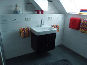 baño blanco con lavabo y ventana en Lütje Sandbank Modern retreat en Juist