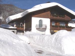 una pila de nieve frente a un edificio en Lovely holiday home near ski-lift en Inzell