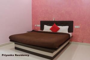A bed or beds in a room at Priyanka Residency