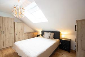 a bedroom with a white bed and a skylight at Appartement Riedingtal in Zederhaus