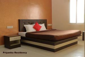 A bed or beds in a room at Priyanka Residency