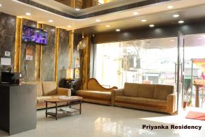 a lobby with two couches and a tv on a wall at Priyanka Residency in Kanchipuram