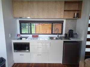 a kitchen with white cabinets and a sink and a window at Modern Couples Getaway in Witta