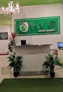 a hotel lobby with a hotel budget sign and two plants at Olive Hotel in Johor Bahru