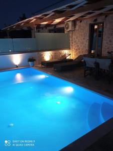 una piscina en una villa por la noche en Villas Goudis, en Tsoukaladhes