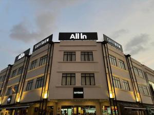 Un gran edificio con un cartel encima. en ALL IN HOTEL, en Kangar