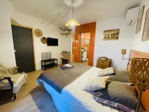 a bedroom with a large bed and a chair at Villa Marcelline - Les Issambres Belle vue mer Golfe de Saint Tropez in Les Issambres