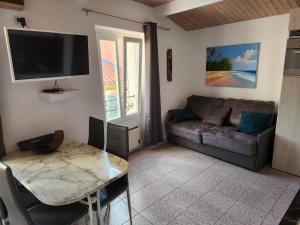 ein Wohnzimmer mit einem Sofa und einem Tisch in der Unterkunft Rue du Vieux Chateau - Beau F2 in Menton