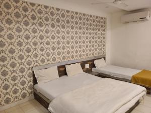 um quarto com duas camas e uma parede em Hotel Motera Inn em Ahmedabad