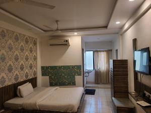 um quarto com uma cama e uma televisão de ecrã plano em Hotel Motera Inn em Ahmedabad