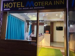 Ein Mann, der an einem Tresen in einem Hotel sitzt. in der Unterkunft Hotel Motera Inn in Ahmedabad