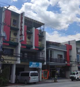 a building with cars parked in front of it at Balai Subik Hotel in Olongapo