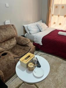 a living room with a couch and a table at JoJo Jovial Homes in Kiambu