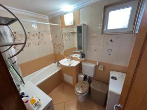een badkamer met een wastafel, een toilet en een bad bij Apartament in Ploieşti