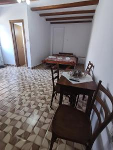 a dining room with a table and chairs and a couch at La Nera in Sasca Română