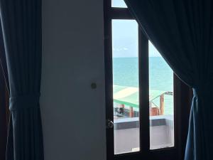 uma vista para o oceano a partir de um quarto com uma janela em Tulip Mui Ne em Phan Thiet