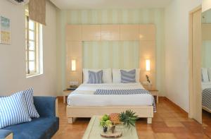 a bedroom with a large bed and a blue couch at Soul Vacation Resort and Spa,Colva in Colva