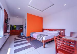 a bedroom with a bed with an orange wall at Vythiri Silver Mist by VOYE HOMES - Hill Top Private Villa in Wayanad in Vythiri