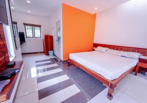 a bedroom with a bed and an orange wall at Vythiri Silver Mist by VOYE HOMES - Hill Top Private Villa in Wayanad in Vythiri
