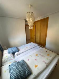 a bedroom with two beds with pillows and a chandelier at Can Guerrero pet friendly a 500 metros de la playa! in Calas de Mallorca