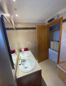a bathroom with two sinks and a mirror at Can Guerrero pet friendly a 500 metros de la playa! in Calas de Mallorca
