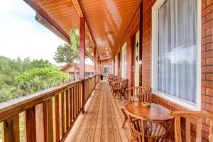 una veranda con tavoli e sedie in legno e una finestra di Collection O 93742 Sidodadi Hotel Dan Resto a Yogyakarta