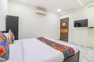 ein Schlafzimmer mit einem Bett und einem TV an der Wand in der Unterkunft FabExpress King Stay in Neu-Delhi