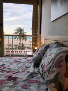 um quarto com uma cama e vista para a praia em Apartamento ARENSOL EN PRIMERA LINEA DE PLAYA em Cullera