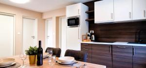 a kitchen with a table with a bottle of wine at HYDE PARK APARTMENTS in Čakovec +81 photos