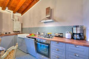 eine Küche mit blauen Schränken und einem Herd mit Backofen in der Unterkunft Laetitia Historic Center Fantastic view L - Happy Rentals in Salò