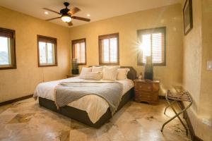 a bedroom with a bed and a ceiling fan at Cabo's Hidden Gem! Steps to the Marina or Beach in Cabo San Lucas +17 photos