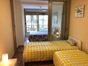 um quarto de hotel com duas camas e um espelho em Apartamento ARENSOL EN PRIMERA LINEA DE PLAYA em Cullera