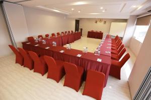 a conference room with a long table and red chairs at Brothers Inn Babarsari in Yogyakarta