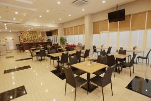 a restaurant with tables and chairs and a stage at Brothers Inn Babarsari in Yogyakarta