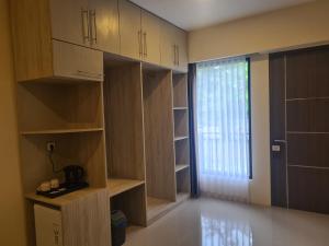 Habitación con estanterías de madera y ventana con puerta en Merpati inn hotel, en Dompu