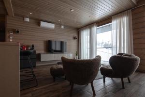 sala de estar con 2 sillas y TV en Kultakero Northern Sky en Pyhätunturi