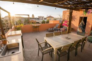 a patio with a table and chairs and a sink at Beachside Bliss Studio, Walk to the Marina and Beach in Cabo San Lucas