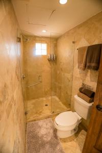 a bathroom with a toilet and a glass shower at Beachside Bliss Studio, Walk to the Marina and Beach in Cabo San Lucas