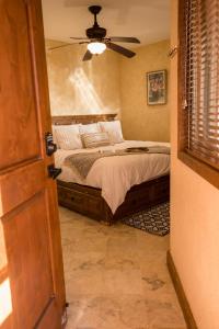 a bedroom with a bed with a ceiling fan at Beachside Bliss Studio, Walk to the Marina and Beach in Cabo San Lucas