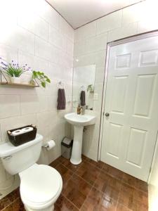 a white bathroom with a toilet and a sink at Mi casa es tu casa. in Quetzaltenango