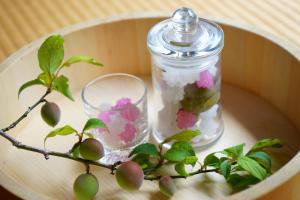 a glass jar with flowers and a plant on a table at 甘糟屋敷 Amakasu Yashiki KAMAKURA in Kamakura