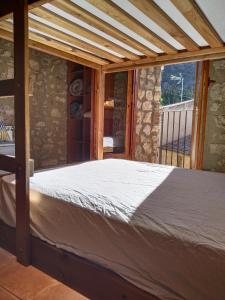 a bed in a room with a stone wall at El Refugi in Arboli +23 photos
