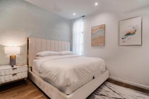een witte slaapkamer met een bed en een raam bij Four Bedrooms Luxurious Townhouse in Los Angeles