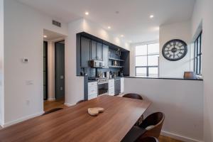 een keuken met een houten tafel en een klok aan de muur bij Four Bedrooms Luxurious Townhouse in Los Angeles