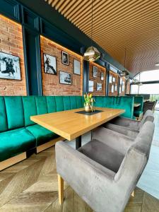 a dining room with a wooden table and green booths at Scandi Marine in Zator