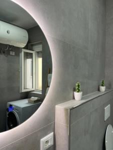 La salle de bains est pourvue d'un miroir et d'un lave-linge. dans l'établissement Peaceful Condo in City Center, à Durrës