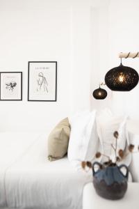 a white couch with pillows and two pictures on the wall at La Roka, Cliffside Memories in Imerovigli +81 photos